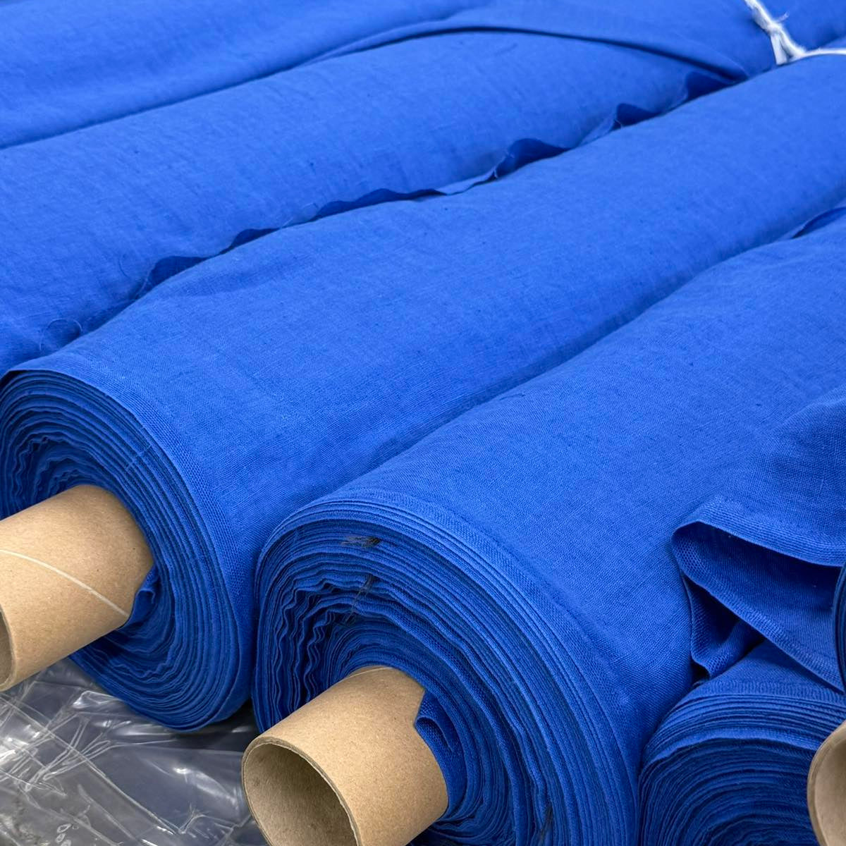 Rolls of blue linen fabric prepared for garment production
