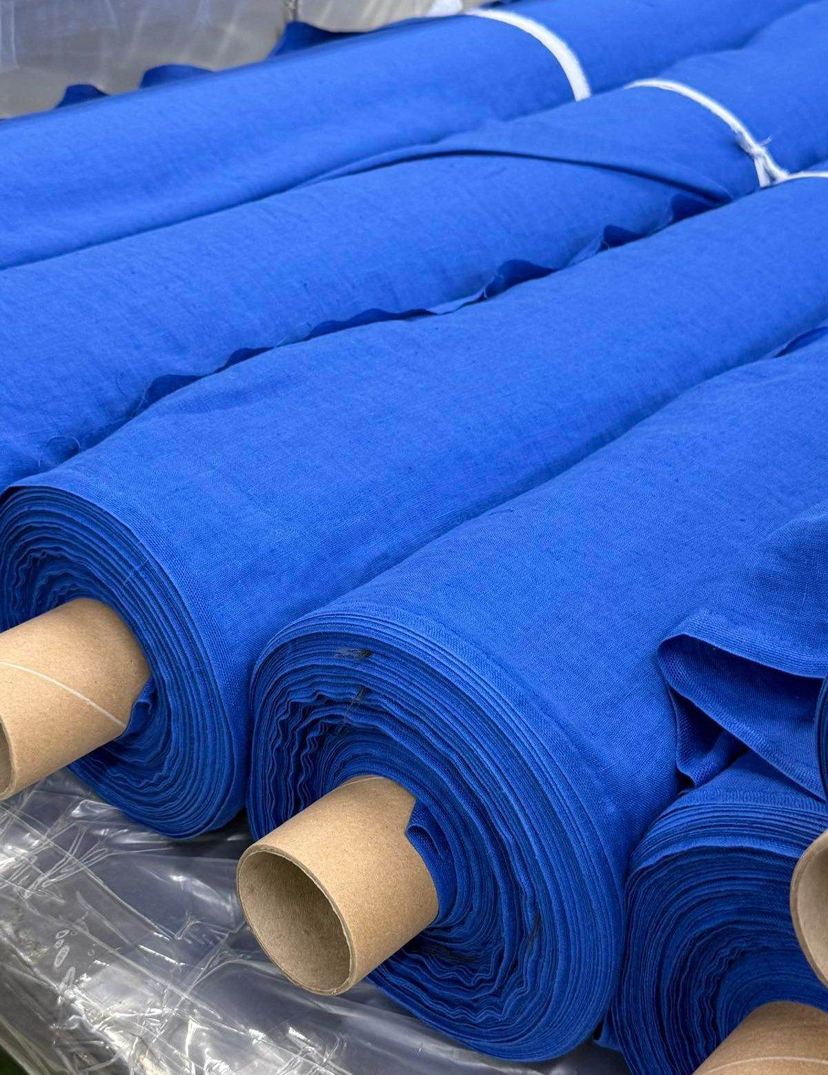 Rolls of blue linen fabric prepared for garment production